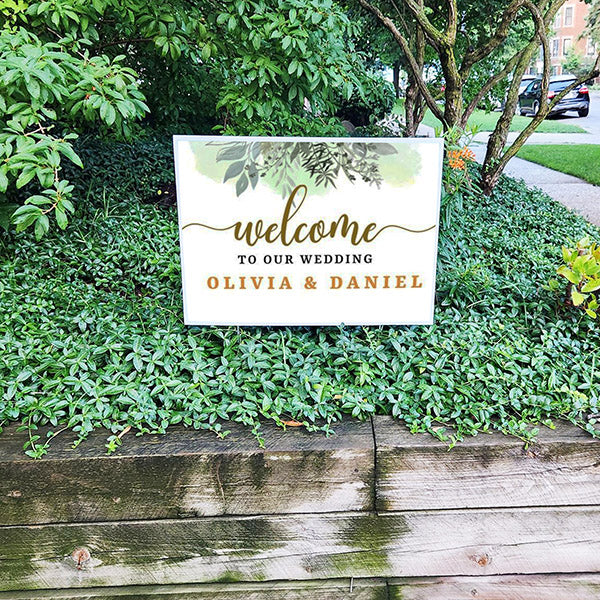 Wedding welcome sign on greenery background displaying "Welcome to Our Wedding Olivia & Daniel".