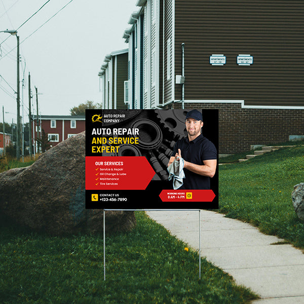 Lawn sign advertising auto repair services with contact information, featuring a mechanic holding a cloth and business hours listed.