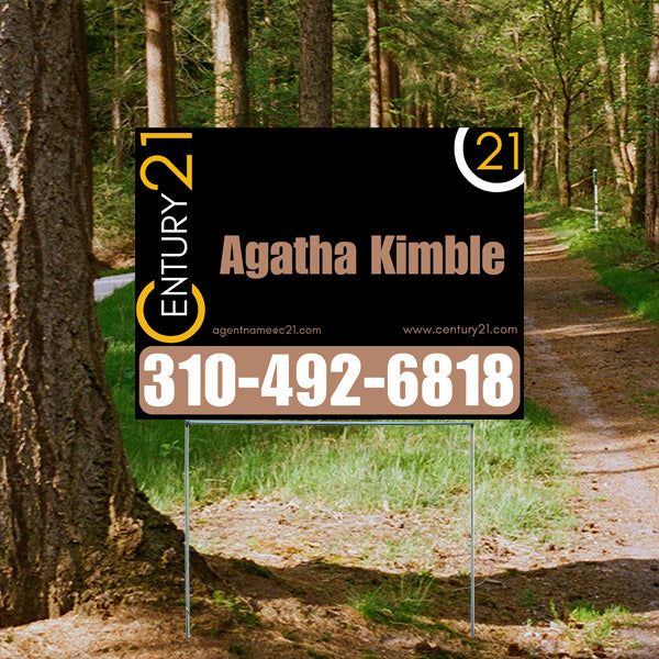 Real estate sign for Century 21 agent with contact name Agatha Kimble and phone number 310-492-6818 displayed outdoors on a forest path.