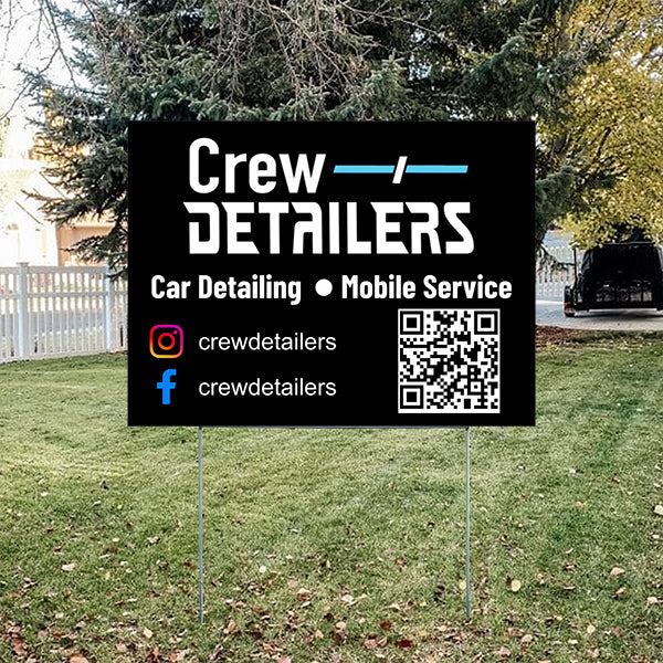 Outdoor sign advertising Crew Detailers car detailing and mobile service, with social media handles and QR code on a grassy lawn.