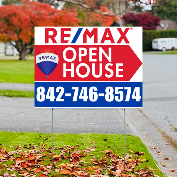 RE/MAX open house sign with contact number 842-746-8574 on a lawn, surrounded by autumn leaves.