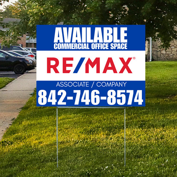 Real estate sign for available commercial office space by RE/MAX with contact number 842-746-8574 placed on a grassy lawn.