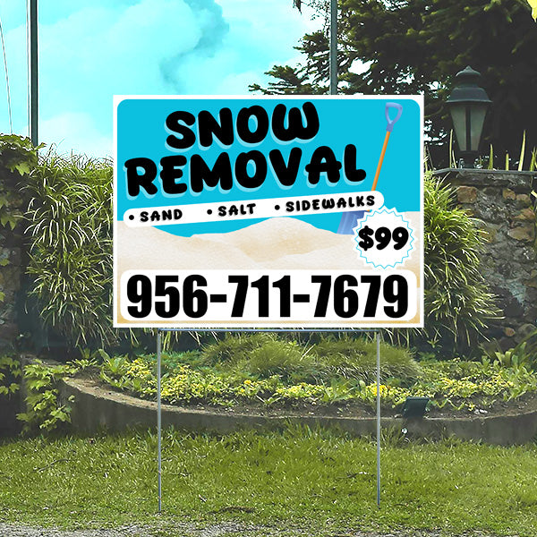 Snow removal service sign with contact number 956-711-7679, offering sand, salt, and sidewalk services for $99, placed in a garden setting.