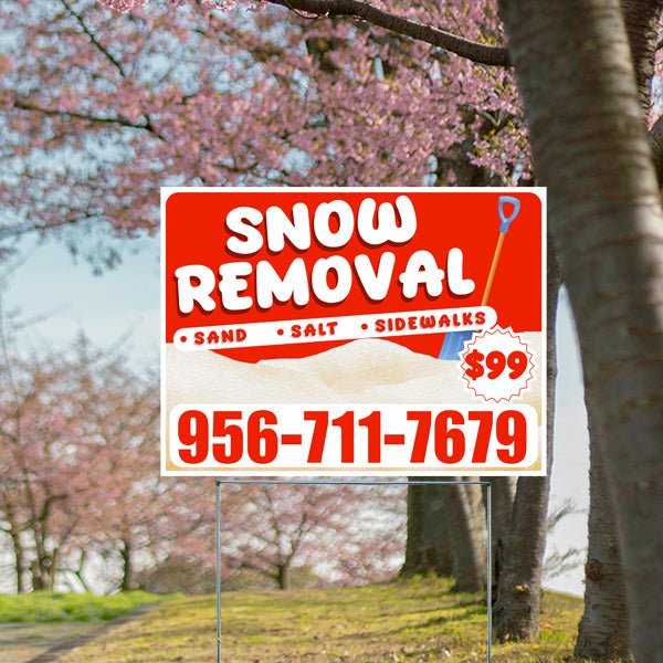 Snow removal service sign with contact number 956-711-7679, priced at $99, featuring options for sand, salt, and sidewalks, set against a backdrop of cherry blossom trees.