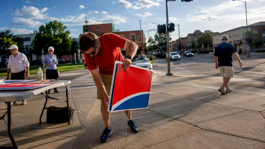 Volunteer installing campaign sign outdoors