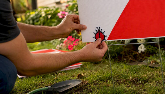 Hands applying union bug to yard sign
