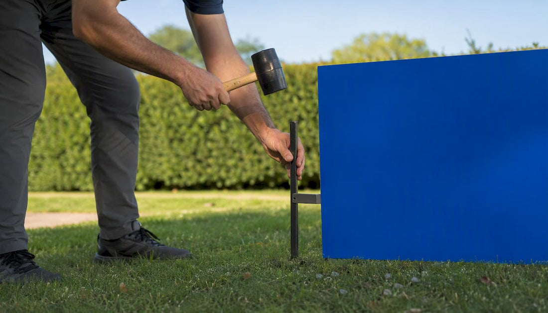 Hand pressing metal stake into lawn for yard sign