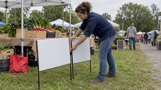 Vendor arranging signs at farmers market stall