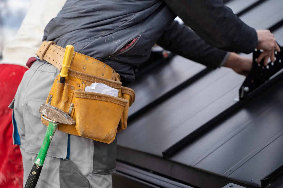 Worker wearing tan leather tool belt with green shovel.