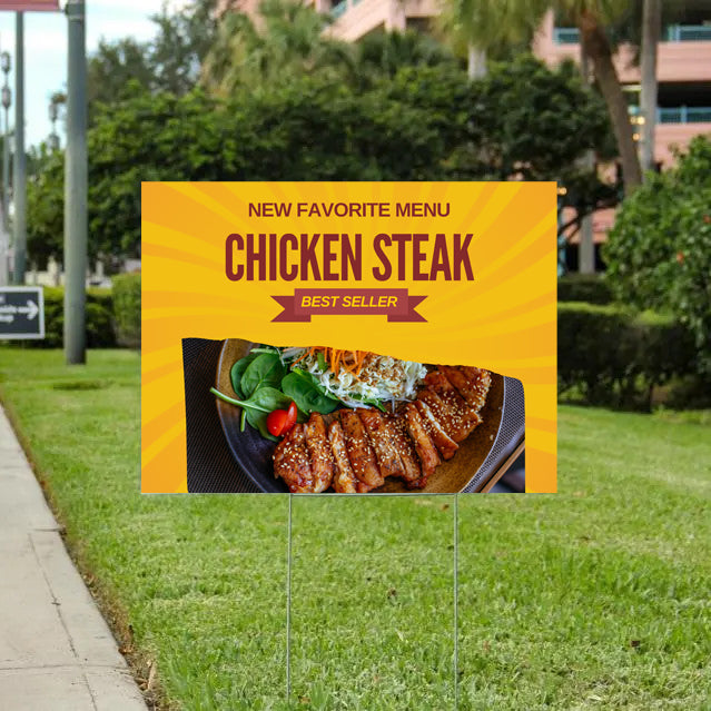 Yellow chicken steak restaurant sign on lawn outdoors