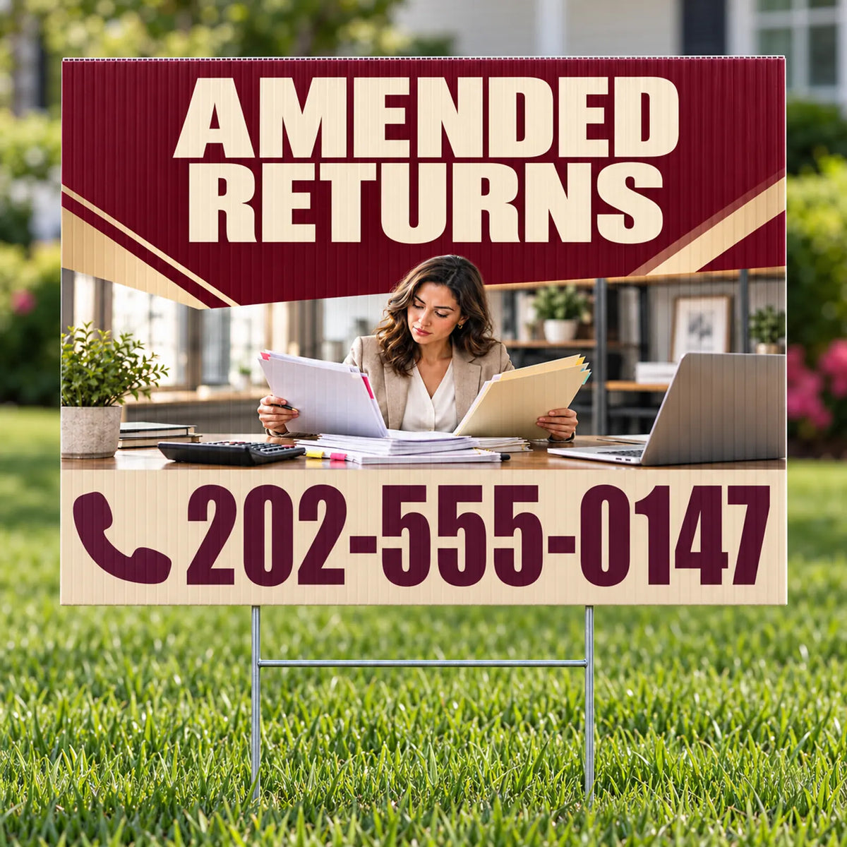 A yard sign on a metal stake displayed on a green lawn. The sign features a maroon and beige design with the text 'AMENDED RETURNS' at the top, a photo of a woman at a desk in the center, and the phone number '202-555-0147' at the bottom.