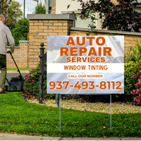 S-yard sign for auto repair services and window tinting with a phone number, placed in front of a house.