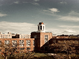 Brick building with a clock tower under a cloudy sky