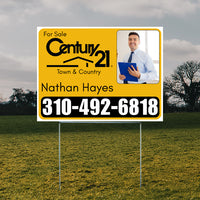 Real estate for sale sign with Century 21 logo, contact information, and image of a professional holding a blue folder.