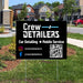 Yard sign for Crew Detailers offering car detailing and mobile service, featuring social media handles and a QR code, in a suburban neighborhood setting.