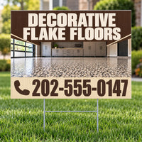 A yard sign on metal stakes displayed in a grassy lawn. The sign features a brown and beige design with the text 'DECORATIVE FLAKE FLOORS' and a phone number, with a photo of a polished concrete floor in the background.
