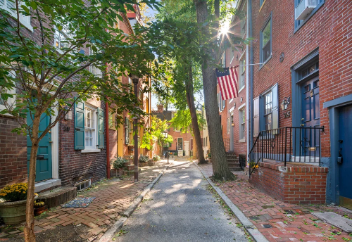 Tiled street with brick houses and American flag in a residential area