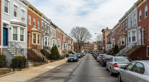 Row of residential houses with parked cars on a street