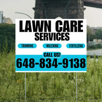 Lawn care services sign with contact information in a grassy area