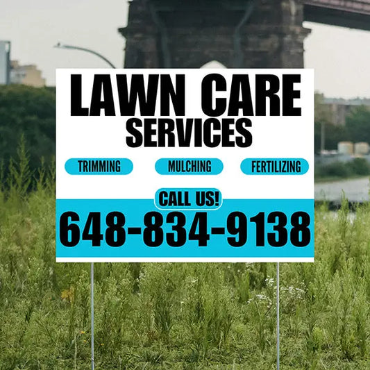 Lawn care services sign with contact information in a grassy area