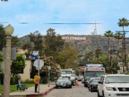 Hollywood sign with traffic and pedestrians in the foreground
