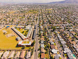 Aerial view of a suburban area with houses, roads, and a school.