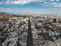 Aerial view of a cityscape with tall buildings and a clear blue sky.