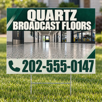 A yard sign on metal stakes displayed in a grassy lawn. The sign features a dark green and white design with the text 'QUARTZ BROADCAST FLOORS' and a phone number, with a photo of a polished concrete hallway in the center.