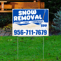 Yard sign advertising snow removal services with phone number 956-711-7679 offering sand, salt, and sidewalk clearing for $99.