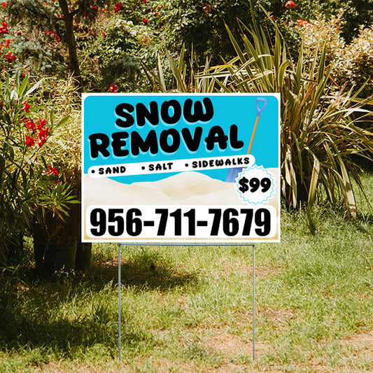 Snow removal service yard sign with contact number 956-711-7679, offering sand, salt, and sidewalk clearing for $99, displayed in a garden setting.