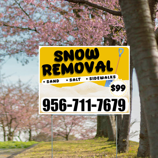 Outdoor sign for snow removal services with sand, salt, and sidewalk options, priced at $99, featuring a shovel graphic and contact number 956-711-7679, with a background of blossoming trees.